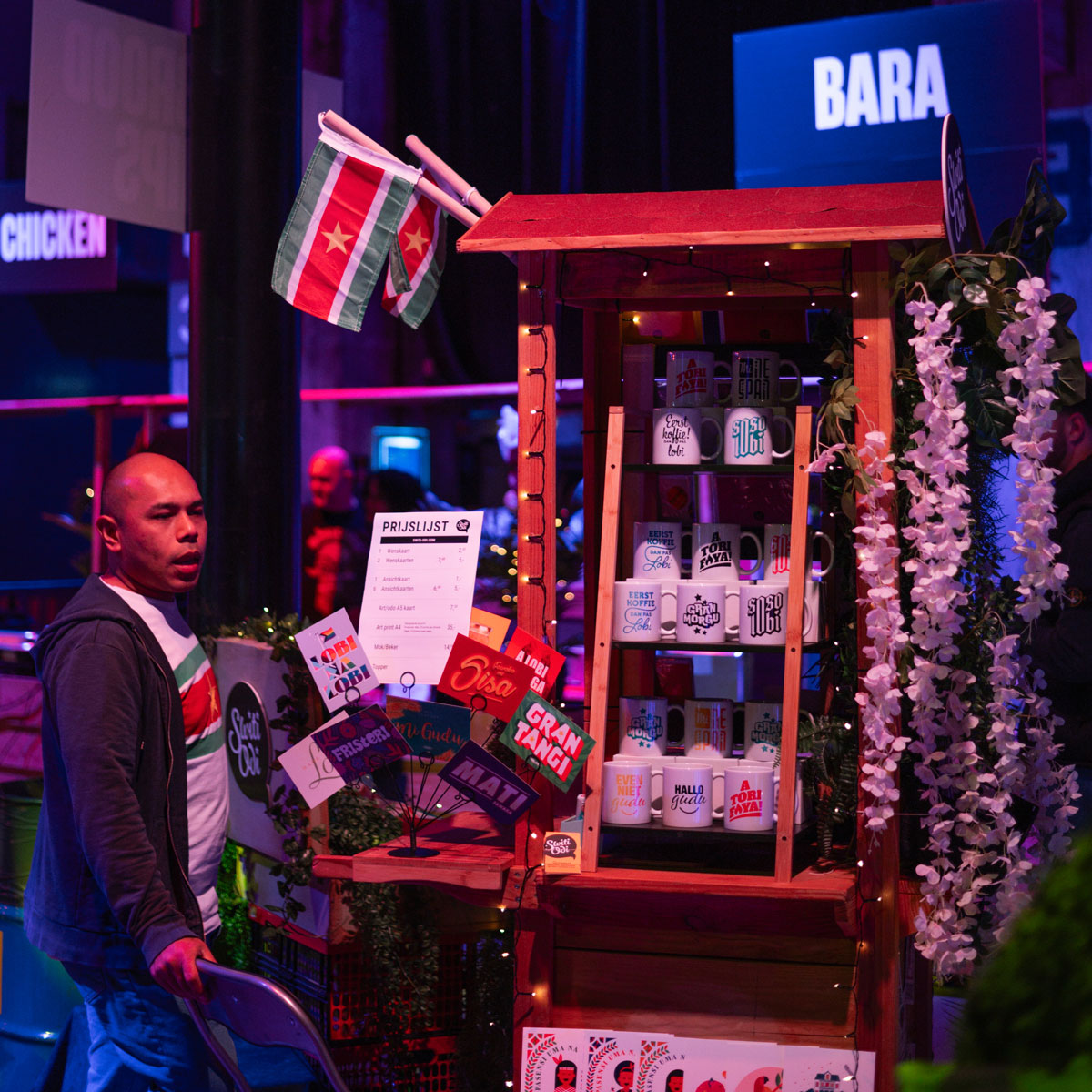 Kraam met mokken en kaarten met Surinaamse teksten